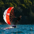 F-One Quest Pocket Wing in red and white with rider on a wingfoil board